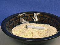 Cereal in a black bowl with a stir rod