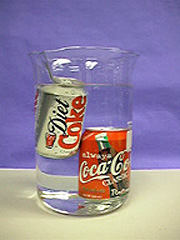 A beaker of water, showing a floating can and a can that rests at the bottom of the beaker