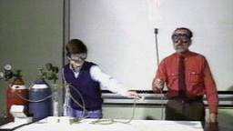 Professor John Moore and assistant performing demonstration with gas tanks and lit torch