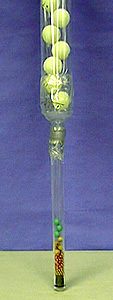 Beads fall through a tube which contains ping pong balls.