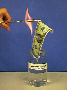 Forceps pass through a flame and hold a burning dollar bill over a jar marked with an identifying label of Isopropanol.
