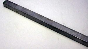 A rectangular dark metal bar on a white surface.