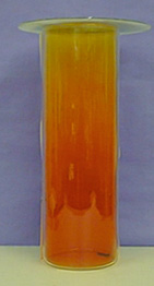 A glass column with layers of dark orange to yellow gas with a dark liquid at the bottom of the column.