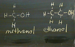 Two formulae on a blackboard, one labeled "methanol" and the other labeled "ethanol"
