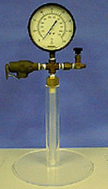 A gauge connected to a cloudy tube. The gauge is attached to a plexiglass stand with a round base.