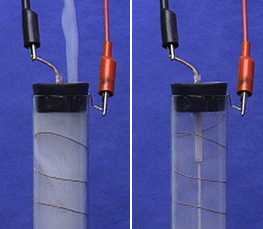In the first photo, gray smoke inside a capped tube with wires spiraling along the sides of the tube. A black lead is connected to an electrode on top of the tube, and a red lead is connected to an electrode on the right side of the tube.  In the second photo, less gray smoke reveals an electrode inside the tube with a black lead connected to an electrode on top of the tube and a red lead connected to an electrode on the inner surface of the tube.