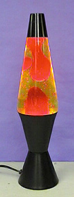 Red liquid floats in a yellow liquid in a lamp with a black cap and base.