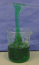 Green gel in a beaker and wrapped around a glass rod.