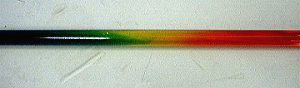 A glass tube with a mixture that shows purple, green,  yellow, and red colors