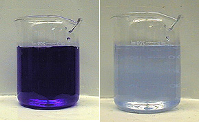 In the first photo, a beaker with dark blue liquid. In the second photo, a beaker with a lighter blue liquid than the liquid seen in the first photo.