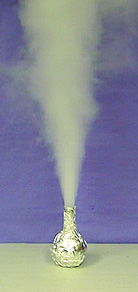 White vapor shoots upward from a flask wrapped in aluminum foil.