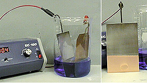 A current is applied to strips of copper and silver in blue solution,  resulting in the copper being deposited on the silver strip.