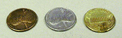 A copper penny, a silver penny, and a gold colored penny