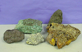 Two dark brown solids, a green solid, a slate-colored solid, and a brown solid with yellow features
