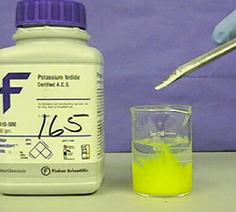 A yellow precipitate forms  in a beaker.
