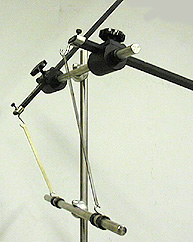 A specialized ring stand holds meter sticks, one hooked to metal and one hooked to rubber