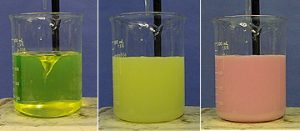 3 beakers with 3 different colored liquids showing reaction progress