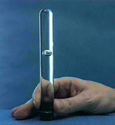 A hand holds a tube with clear colorless liquid, and a bubble appears in the liquid.