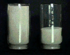 One container is filled with gray-white sand. A partially full second container of sand rests next to it.