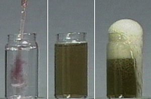 Clear pink liquid from a dropper is added to a clear liquid in a jar, and a pink color is seen. In the second photo, an uncapped jar contains green liquid. In the third photo, white foam runs over the edge of the jar with green liquid.