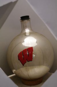 A stoppered glass flask with a red letter "W." A silver coating is seen on the inside of the flask.