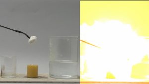An empty beaker next to a candle and forceps holding a white solid over it, next to a large beaker of clear liquid. In the second photo, a rod engulfed in while light and yellow flame due to combustion.